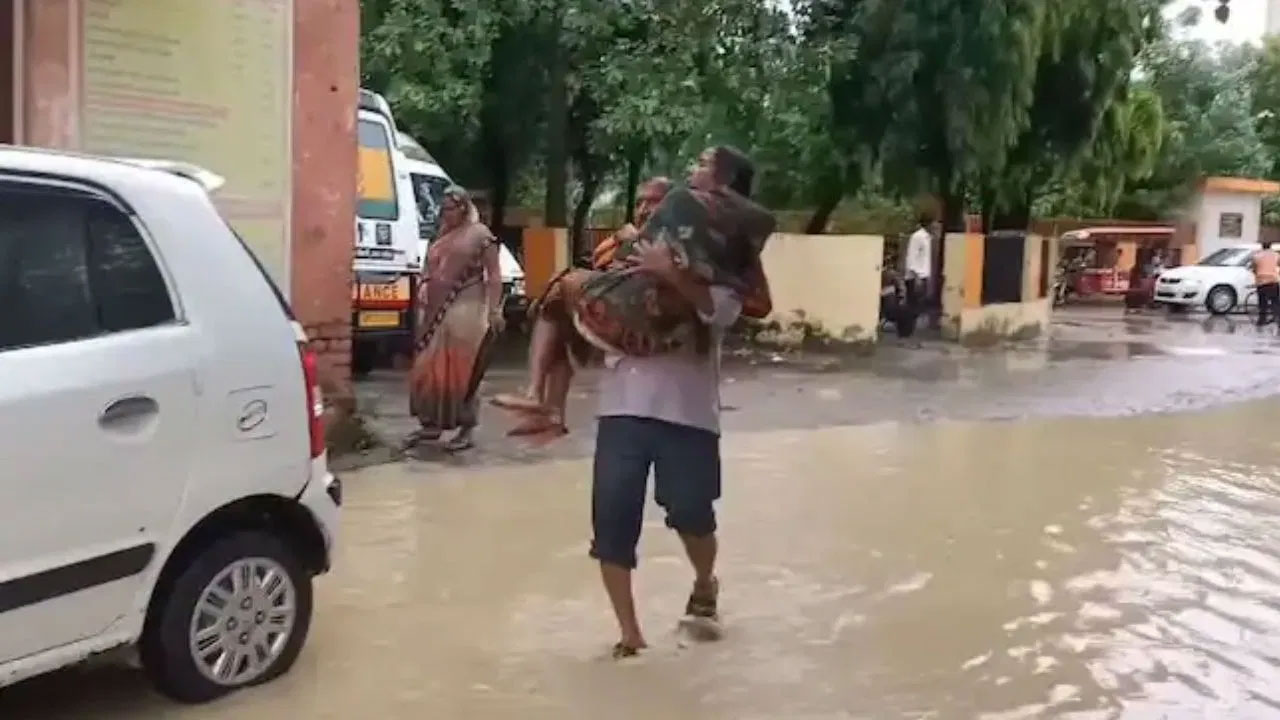 রাস্তায় জমে পানি, স্ত্রীকে কোলে নিয়ে হাসপাতালের পথে স্বামী